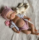 a sleeping reborn doll girl made of silicone on bed